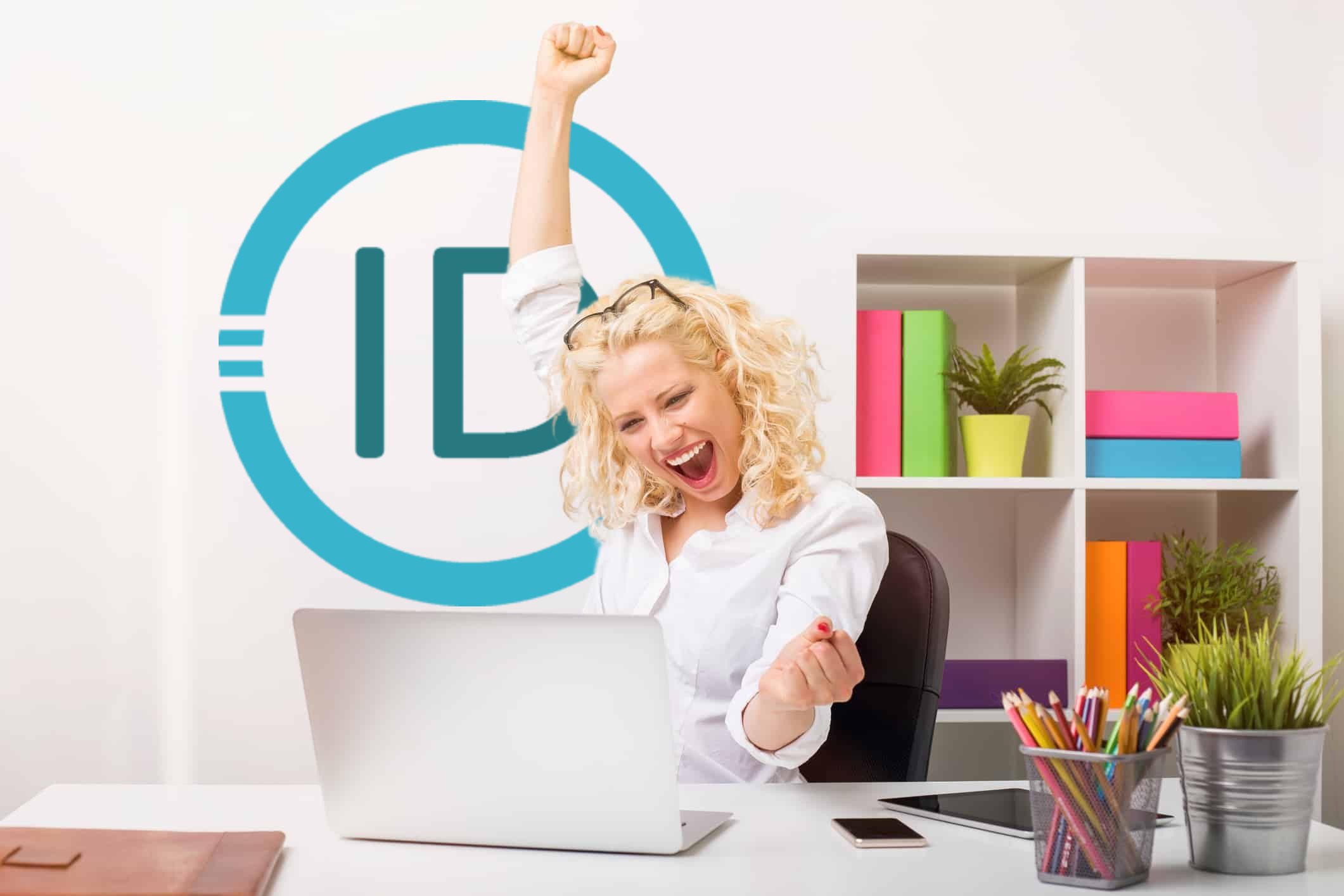 Excited woman celebrating success at laptop in office.