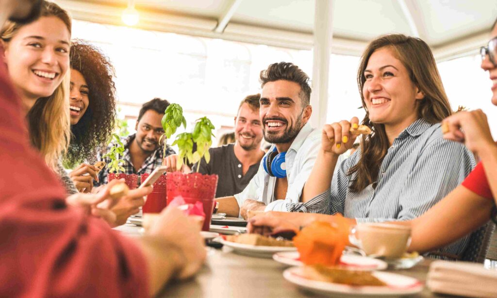 Friends enjoying meal together at cafe table.