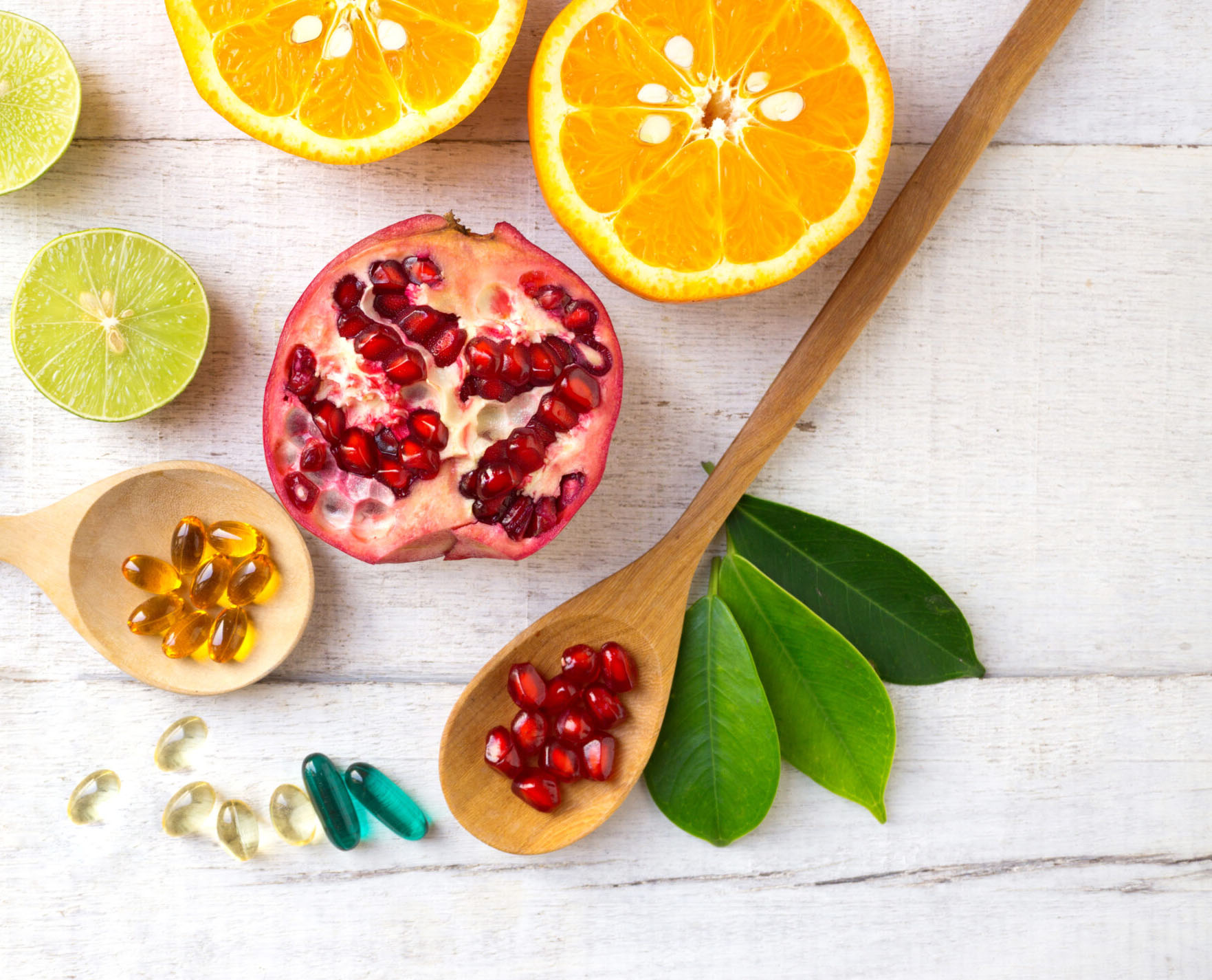 Assorted fruits and vitamins on wooden background.